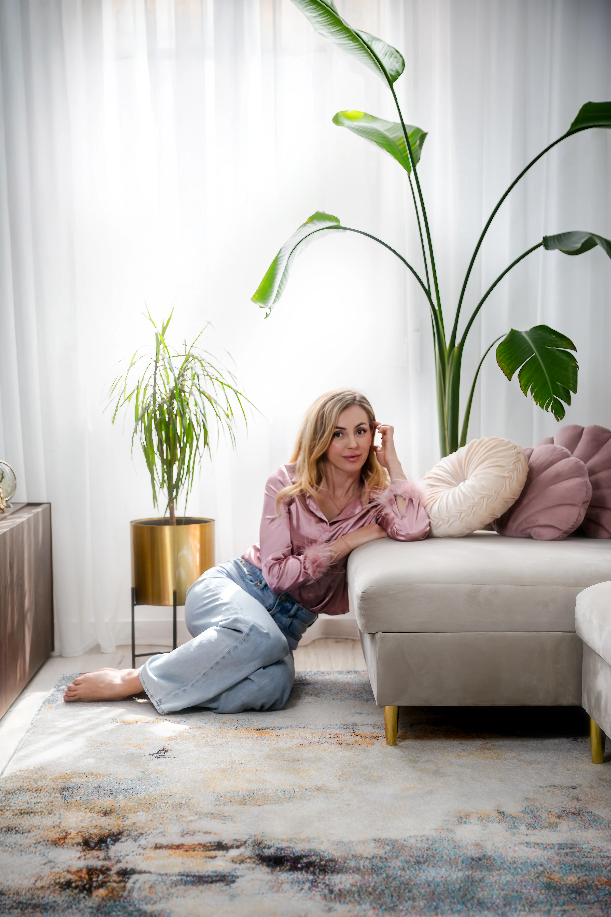 Valentyna relaxing beside a sofa in a calm home setting