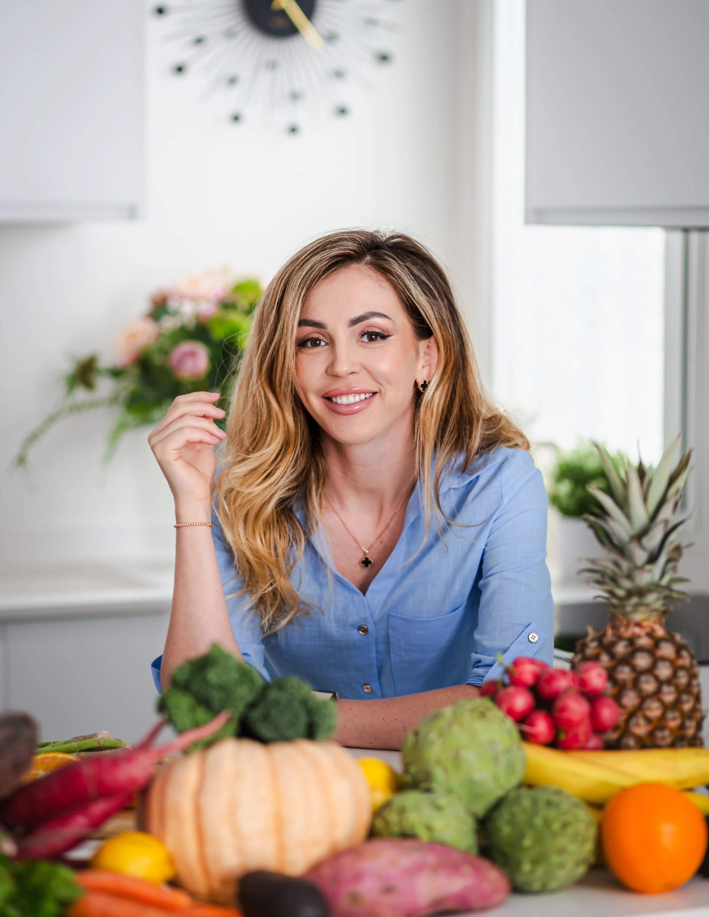 Valentyna sitting in a bright kitchen with fresh produce